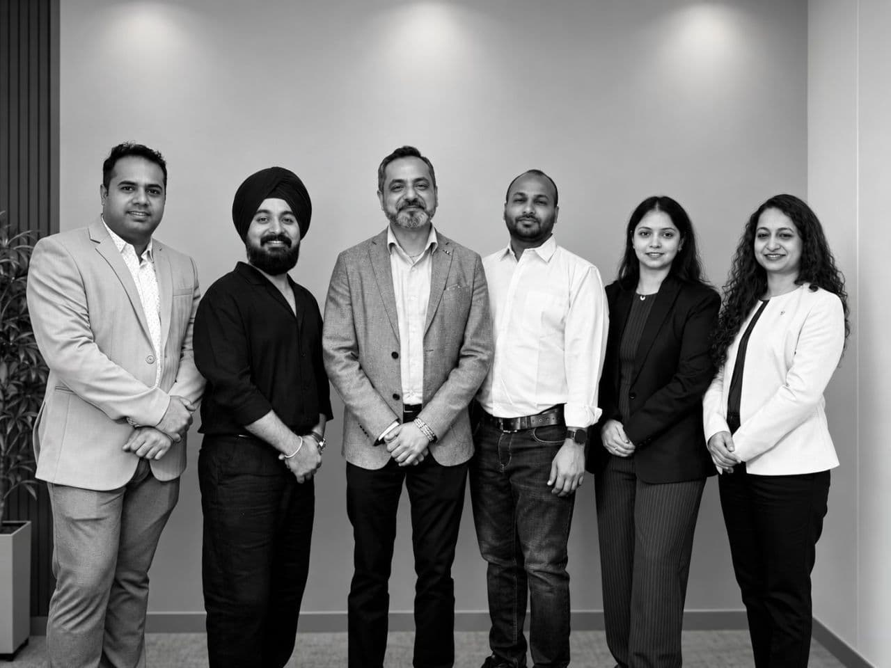 Some of the BrokViser founding team members standing together indoors, smiling toward the camera.